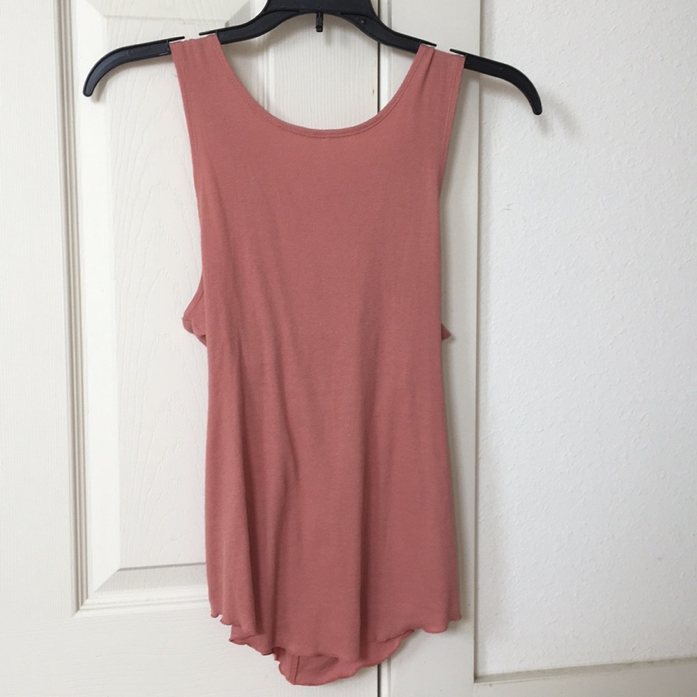 A pink coral tank top with a twisted back